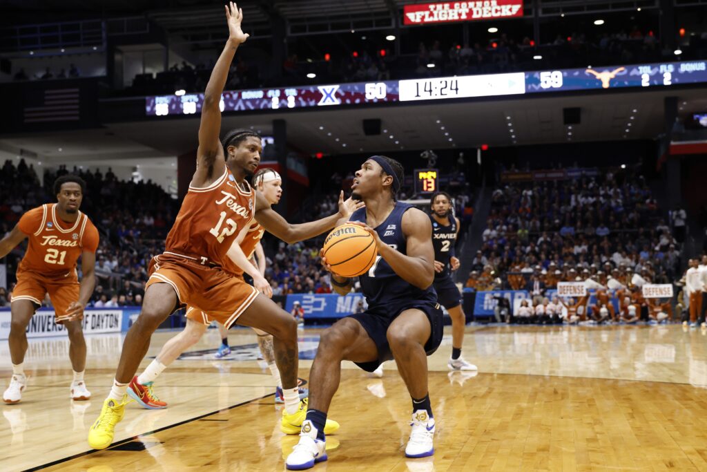 Mar 19, 2025; Dayton, OH, USA; Xavier Musketeers guard Ryan Conwell (7) dribbles the ball defended by Texas Longhorns guard Tramon Mark (12) in the second half at UD Arena. Mandatory Credit: Rick Osentoski-Imagn Images