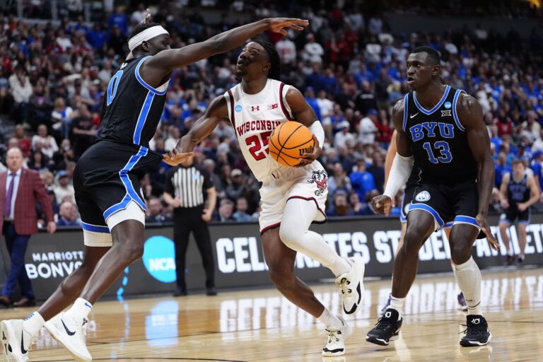 Mar 22, 2025; Denver, CO, USA; Wisconsin Badgers guard John Blackwell (25) dribbles the ball against Brigham Young Cougars forward Mawot Mag (0) and center Keba Keita (13) during the second half in the second round of the NCAA Tournament at Ball Arena. Mandatory Credit: Ron Chenoy-Imagn Images