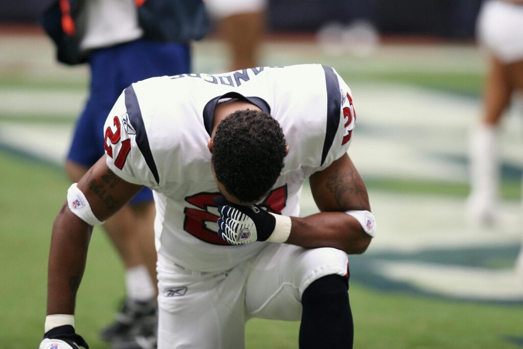 A football player kneeling down on one knee during a match.