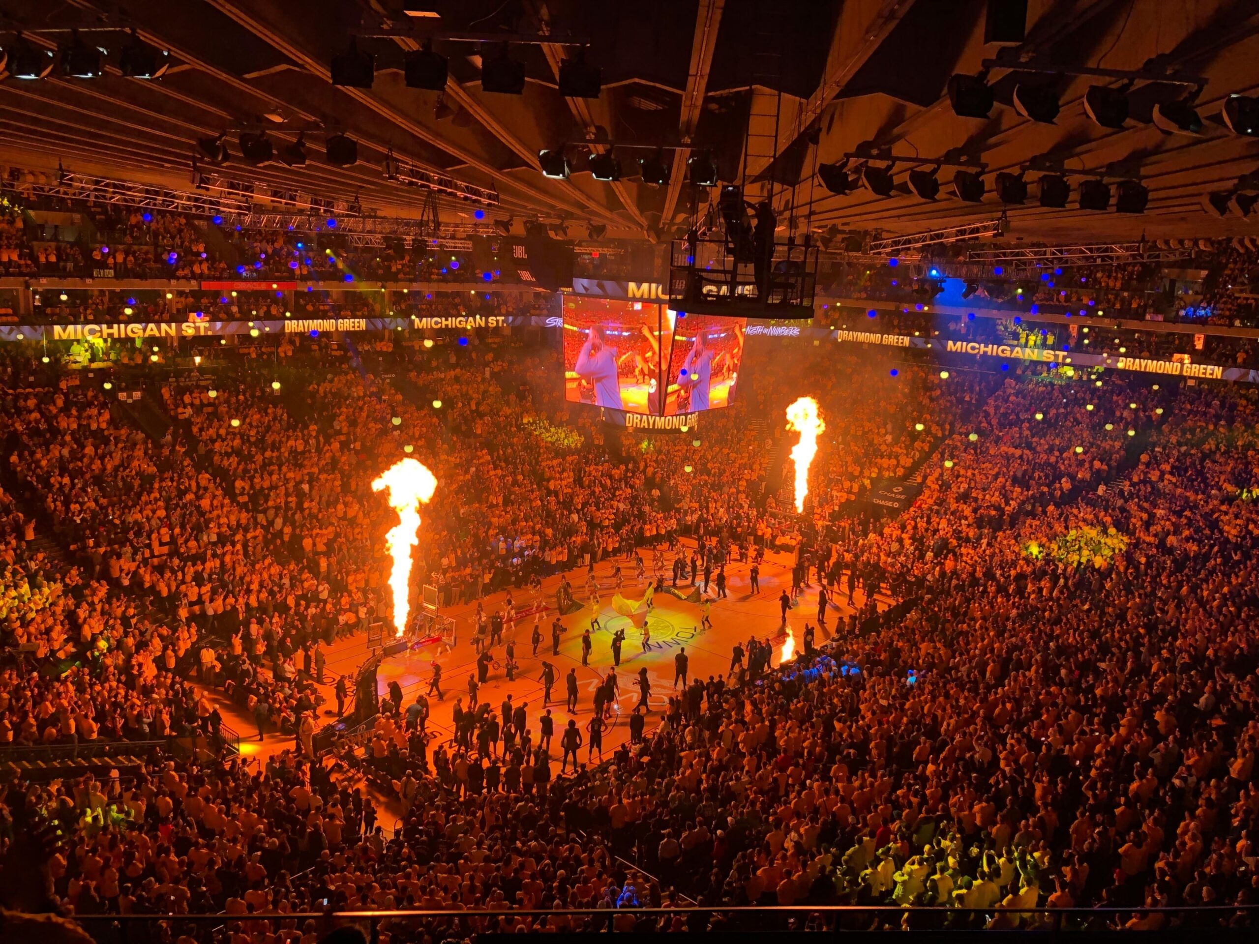 A stadium with lots of fans watching an NBA game.