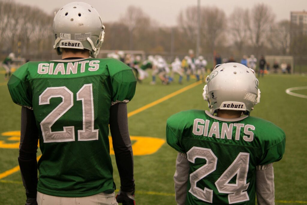 Two Giants players standing on the sidelines of the pitch.